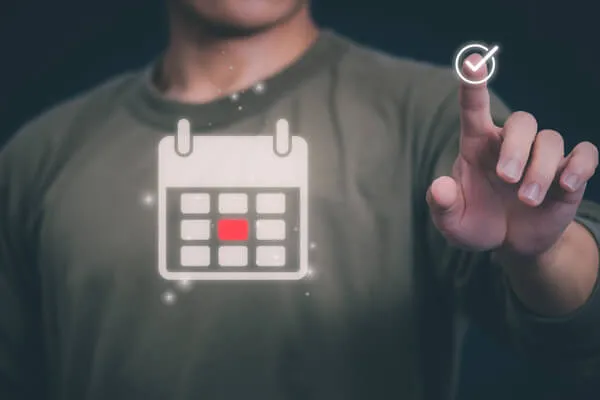 Man with calendar overlaying his chest clicking a check mark with his finger.